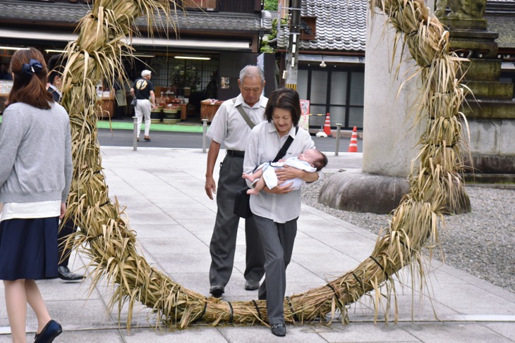 多賀大社の茅の輪をくぐりご祈祷に行くお宮参りのスナップ写真